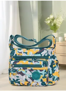 Detail view of water-resistant patterned crossbody bag with multiple zip pockets