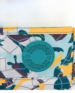 Detail of mint green rubber logo and stitching on floral oxford fabric shoulder bag