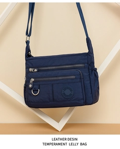 Detail of dark blue waterproof oxford crossbody bag with multiple zipper compartments