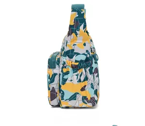 Side view of multi-pocket floral print crossbody bag made of water-resistant oxford fabric