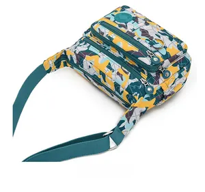 Detail view of multi-compartment water-resistant nylon crossbody bag with geometric print