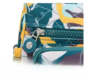 Close-up of smooth plastic zipper and round metal puller on geometric printed oxford bag