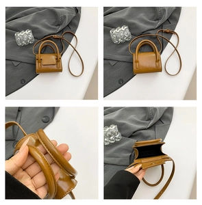 Macro detail of caramel brown mini handbag with glossy leather finish and dual handles