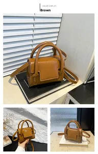 Detail view of mini brown leather handbag with glossy finish and adjustable shoulder strap