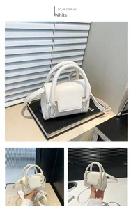 Close-up of a white mini handbag with textured leather finish and elegant handle detail