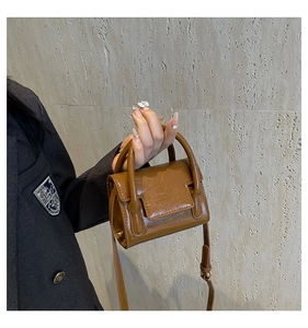 Détail du mini sac à main en cuir caramel avec texture plissée et bandoulière ajustable