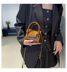 Détail du mini sac à main avec texture crocodile marron et bandoulière réglable