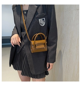 Mini sac bandoulière marron brillant porté par un mannequin pour référence de taille