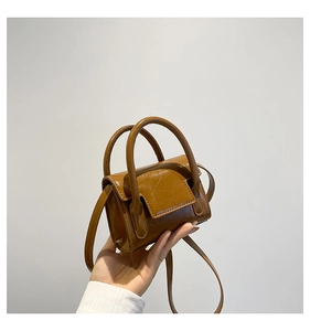Détail du mini sac à main brillant marron caramel avec texture plissée et fine bandoulière