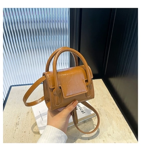 Gros plan détaillé d'un mini sac à main marron vintage avec texture froissée et rabat poli