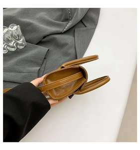 Vue de dessus du mini sac bandoulière marron montrant l'intérieur et la texture du cuir PU