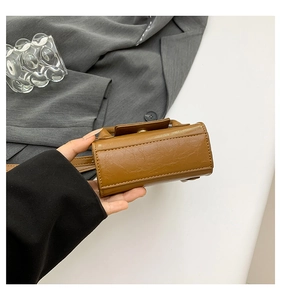 Détail du fond rectangulaire avec des coutures uniformes sur un mini sac en cuir marron