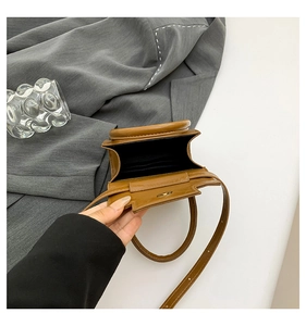Détail intérieur d'un mini sac carré marron montrant le porte-carte et le fermoir magnétique