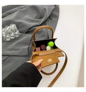 Détails de l'intérieur d'un mini sac bandoulière marron montrant le rangement de rouge à lèvres