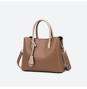 Detail of dark brown pebble leather tote bag with snakeskin texture handles and gold hardware