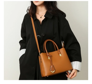 Brown lychee leather tote bag with crocodile texture charm and adjustable shoulder strap