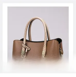 Detail of brown tote bag showing lychee grain texture and crocodile pattern handles