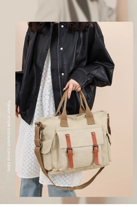 Detail of canvas messenger bag featuring vintage flap pocket and adjustable strap