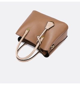 Macro detail of brown lychee leather tote bag with beige croc texture handles and gold metal hardware