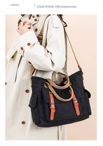 Close-up of black canvas crossbody bag with leather buckles and functional side pockets