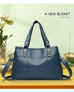 Detail of navy blue pebble leather handbag featuring diamond-set silver buckles and stitching