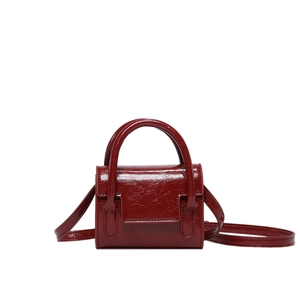 Mini sac à main bordeaux en cuir verni avec poignées rigides et texture plissée chic