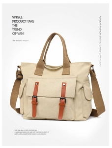 Detail of canvas messenger bag featuring large front pockets and brown webbing handles