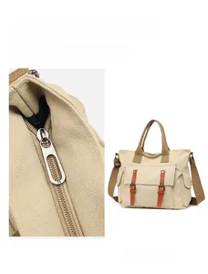 Detail of silver metal zipper puller and large capacity khaki canvas travel handbag