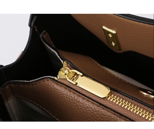Close-up of brown lychee grain leather tote bag with gold zipper and neat stitching