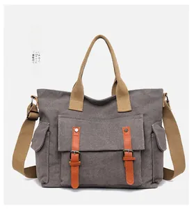 Close-up of retro canvas tote bag with orange leather straps and khaki handles