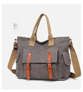 Detail showing multi-pocket gray canvas tote bag with adjustable straps and leather buckles