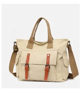 Detailed view of beige canvas crossbody bag with brown straps and dual front pockets