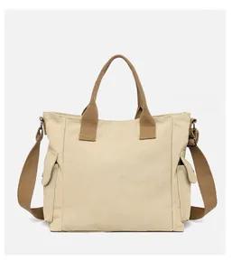 Detail of canvas tote bag with brown handles and side flap pockets in macro view