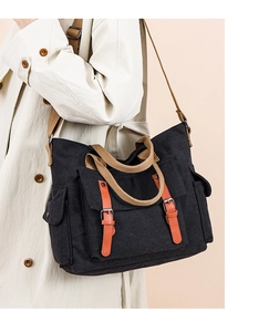 Detail of vintage canvas crossbody bag with contrast straps and leather buckle on model