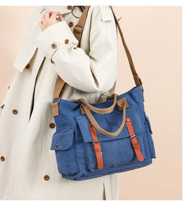 Detail of vintage navy canvas messenger bag with brown leather straps and metal buckles
