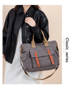 Detail view of large grey canvas bag with brown handles and orange leather buckle straps
