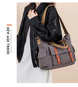 Detail of gray canvas messenger bag featuring vintage leather straps and metal buckles