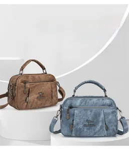 Close-up of textured faux leather handbags with kangaroo logo and multiple compartments