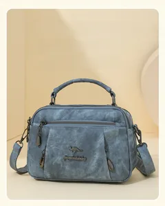 Close-up of blue denim texture handbag featuring multiple zipper pockets and metal accents