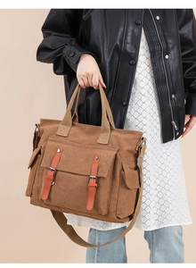Detail of vintage canvas crossbody bag with dual front pockets and leather strap accents