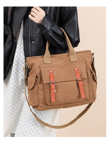Brown canvas crossbody bag with orange leather accents worn by a model in casual style