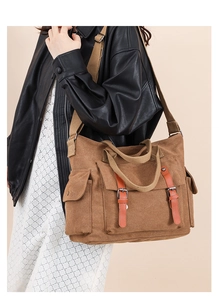 Detail of vintage canvas messenger bag with leather straps and multiple pockets
