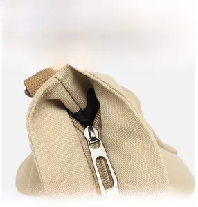 Close-up of durable canvas texture with smooth metal zipper and brown woven strap detail