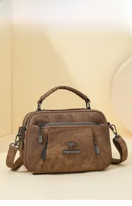 Close-up of brown textured crossbody bag with multiple zippers and brand logo detail