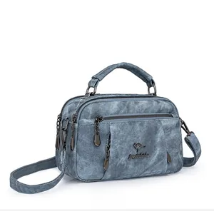 Blue denim texture handbag with dual zipper compartments and kangaroo logo detail