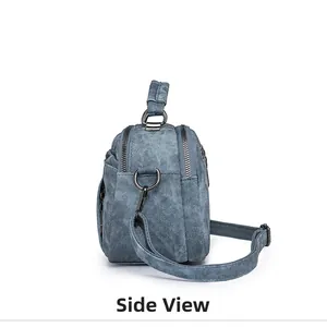 Side view of blue denim texture handbag with dual zippers and gunmetal grey hardware