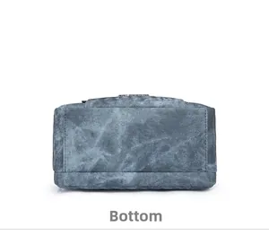 Detail view of the rectangular bottom of the blue twill texture handbag with double stitching
