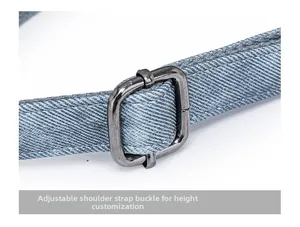 Detailed close-up of light blue denim shoulder strap with adjustable metal buckle