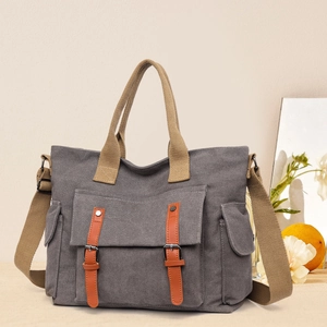 Vintage grey canvas tote bag with brown handles and orange leather straps for travel