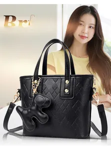 Detail of black pebbled leather bucket bag with quilted patterns and cute dog charm